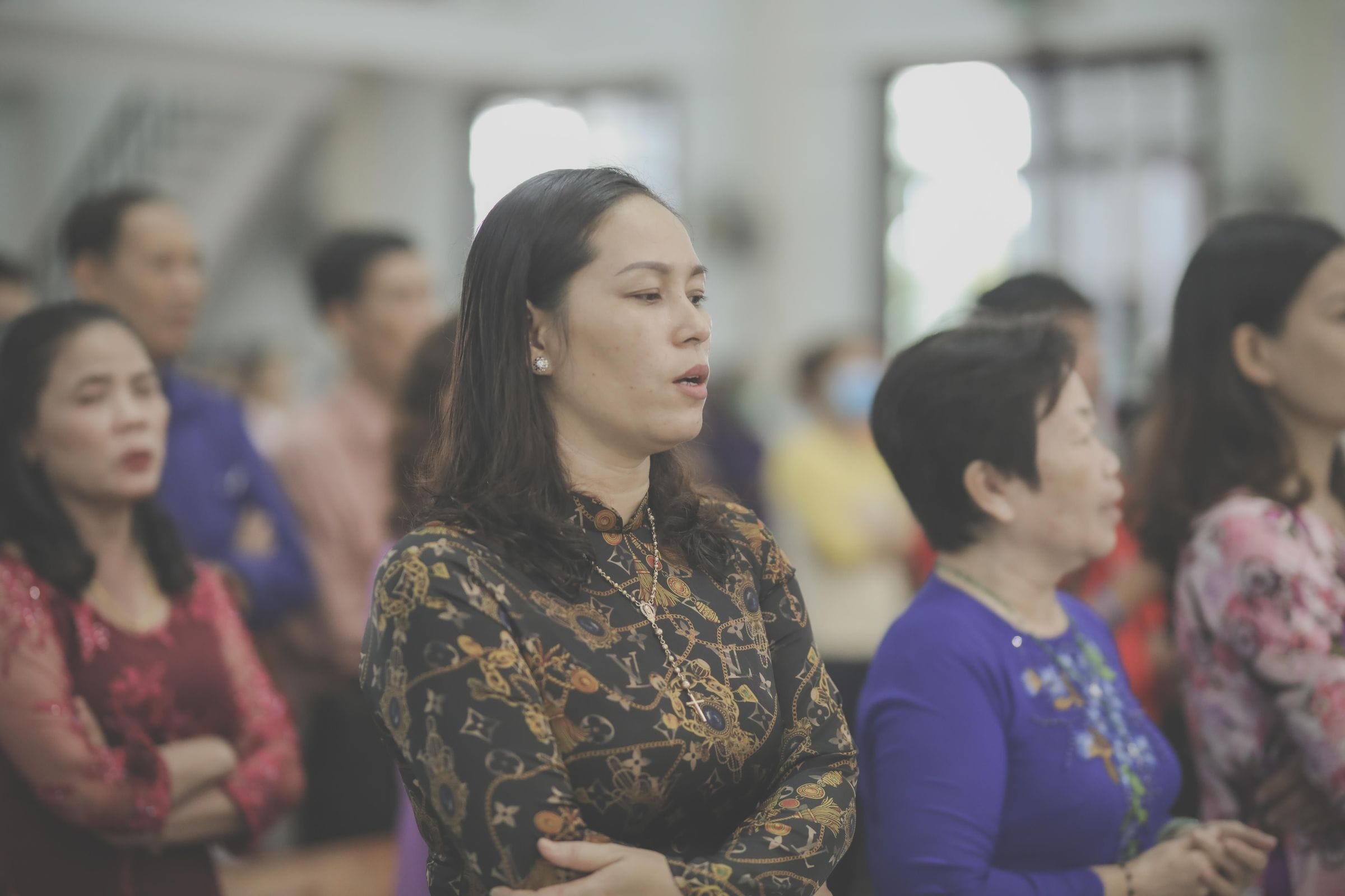 Mujeres de pie, una junto a otra, durante un servicio en la iglesia.